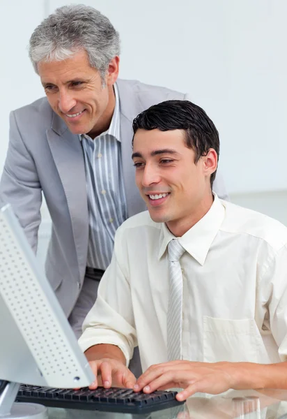 成熟的商人，帮助他的同事在一台计算机 — 图库照片