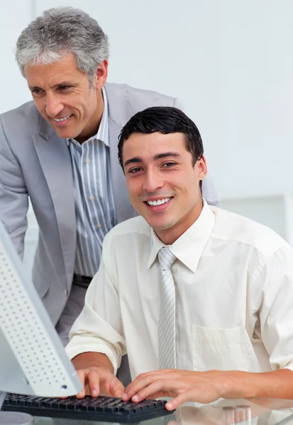 Selbstbewusster Geschäftsmann hilft seinem Kollegen am Computer — Stockfoto