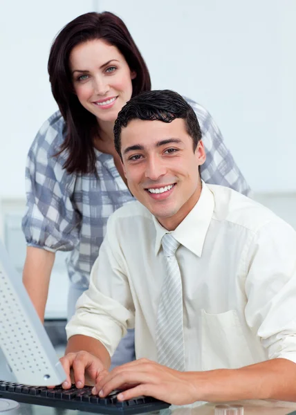 Assertive empresária ajudando seu colega em um computador — Fotografia de Stock