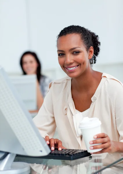 Blij zakenvrouw houden een drinkbeker op haar Bureau — Stockfoto