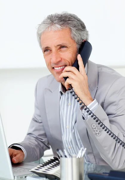Позитивный зрелый бизнесмен разговаривает по телефону — стоковое фото