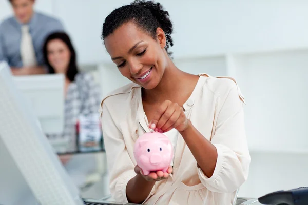 Positiva affärskvinna spara pengar i en spargris — Stockfoto