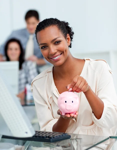Mulher de negócios sorrindo economizando dinheiro em um banco porquinho — Fotografia de Stock