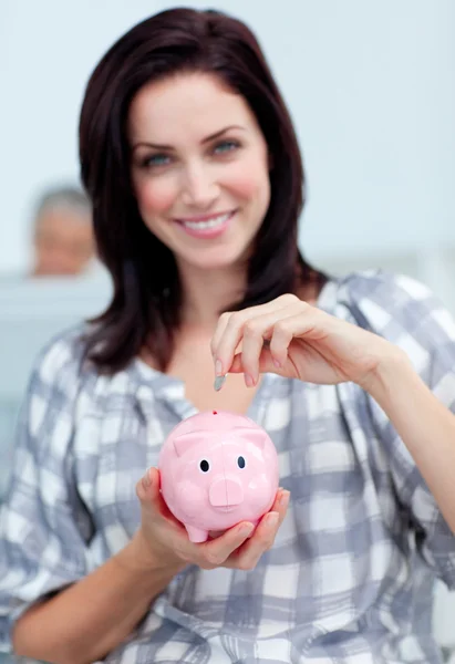 Charismatische Geschäftsfrau spart Geld in Sparschwein — Stockfoto