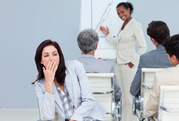 Скучная деловая женщина зевает на презентации — стоковое фото