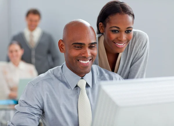 Socios de negocios sonrientes trabajando juntos en una computadora — Foto de Stock