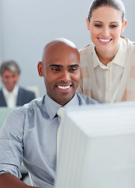 Empresária confiante ajudando seu colega em um computador — Fotografia de Stock