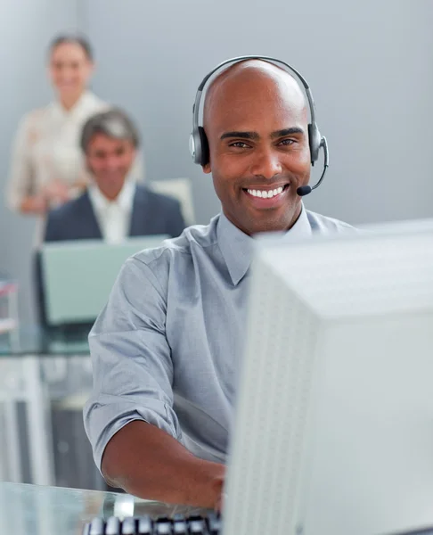 Confident businessman with headset on working at a computer — Stock Photo, Image