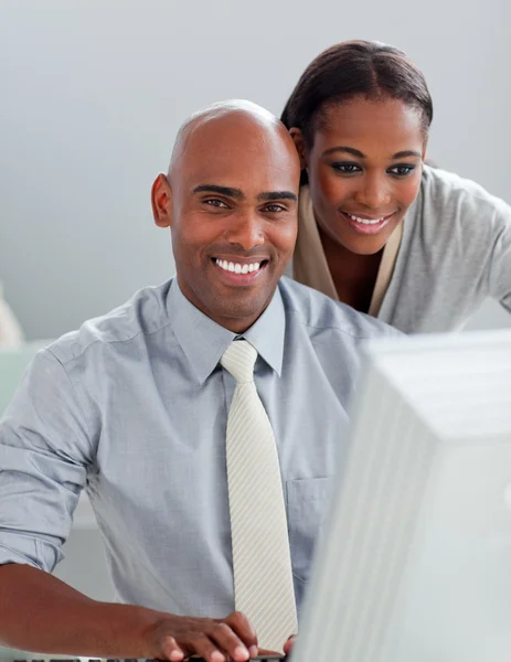 Charming businesswoman helping her colleague at a computer — Stock Photo, Image
