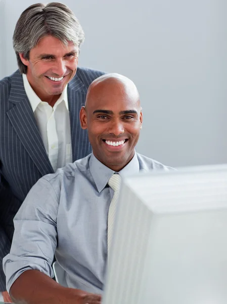 Homem de negócios maduro ajudando seu colega em um computador — Fotografia de Stock