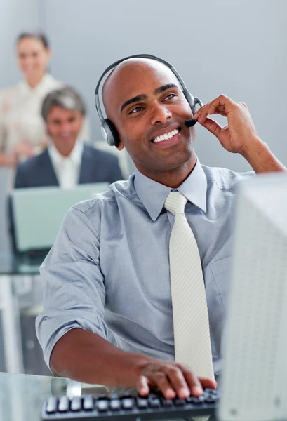 Vrolijke zakenman werkt op een computer met hoofdtelefoon op — Stockfoto