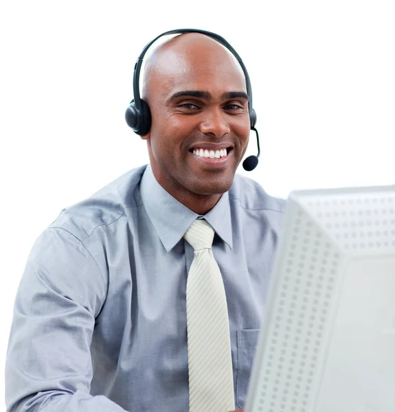 Homem de negócios feliz falando no fone de ouvido em um computador — Fotografia de Stock