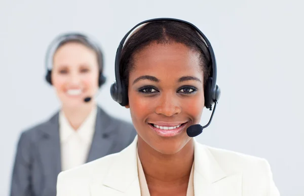 Ethnic businesswoman and her colleague with headset on — Stock Photo, Image