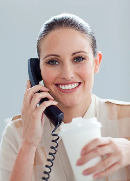 喝一杯咖啡的电话上的白种人女商人 — 图库照片