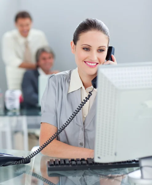 Vertrouwen zakenvrouw op telefoon werkt op een computer — Stockfoto