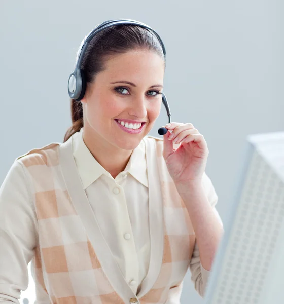 Charming businesswoman working at a computer with headset on — Stock Photo, Image