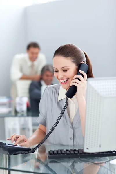 Uśmiechnięta kobieta na telefon na biurku — Zdjęcie stockowe