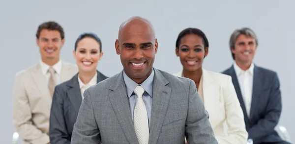 Charismatischer ethnischer Geschäftsmann mit lächelndem Team — Stockfoto