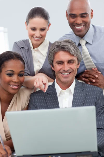 Uma equipe de negócios mostrando diversidade étnica usando um laptop — Fotografia de Stock