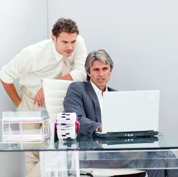 Confident manager helping his colleague work at a computer — Stock Photo, Image