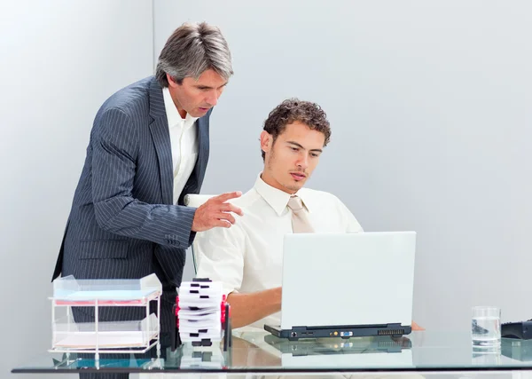 Συμπυκνωμένο διευθυντής βοηθώντας τον συνάδελφό του λειτουργεί σε έναν υπολογιστή — Φωτογραφία Αρχείου
