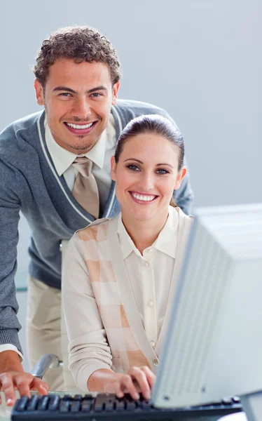 Handsome businessman helping his colleague work at a computer — Stock Photo, Image
