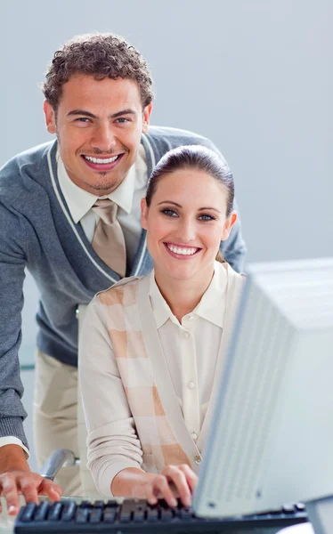 Schöner Geschäftsmann, der seinem Kollegen bei der Arbeit am Computer hilft — Stockfoto