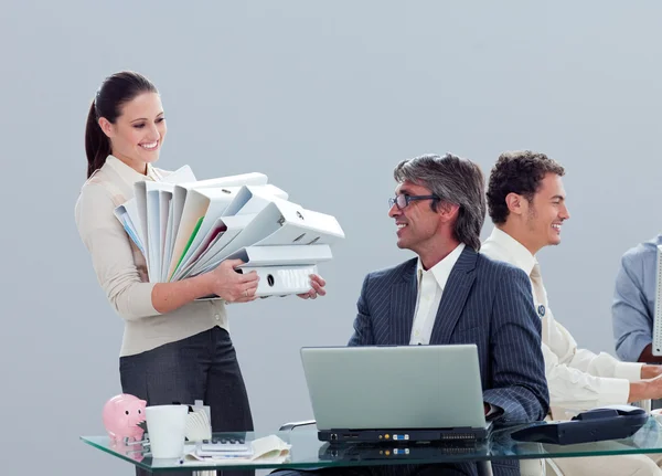 Pretty businesswoman carrying a stack of folders with her collea — Stock Photo, Image