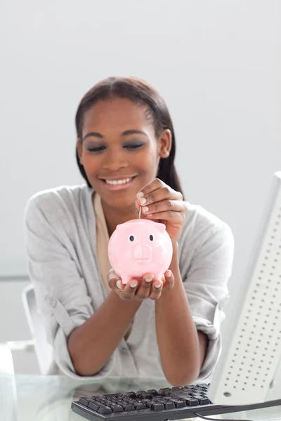 Afro-American affärskvinna spara pengar i en piggybank — Stockfoto