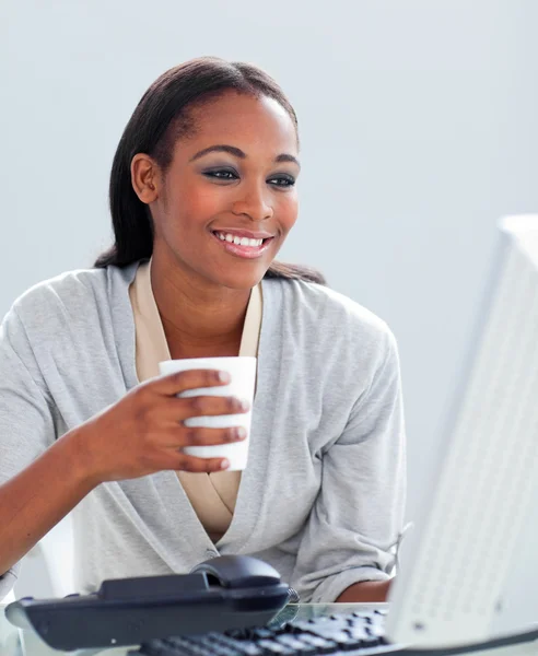 Уверенная деловая женщина пьет кофе за своим столом — стоковое фото