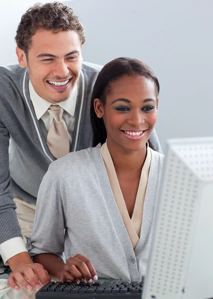 Hombre de negocios sonriente ayudando a su colega en una computadora —  Fotos de Stock