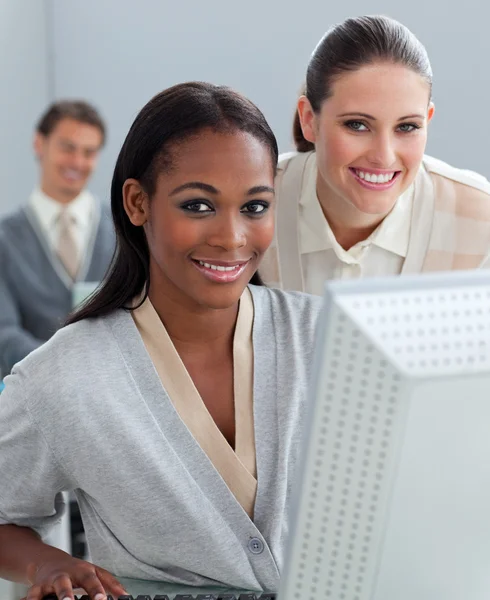 Femme d'affaires charismatique aidant son collègue à un ordinateur — Photo