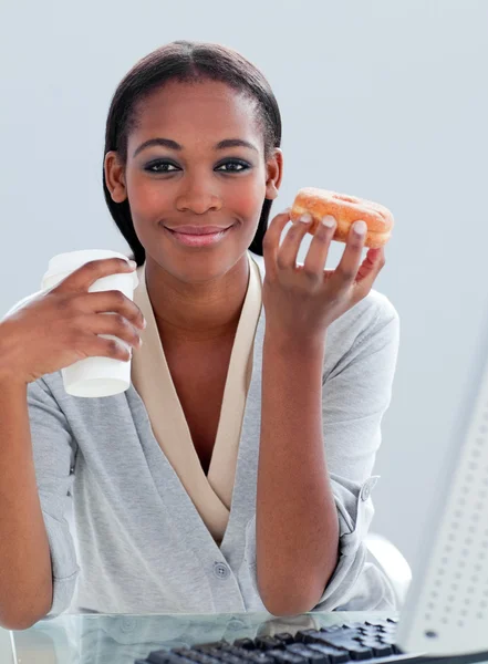 Portrait of an ethnic businesswoman drinking coffee and eating d — Stock Photo, Image