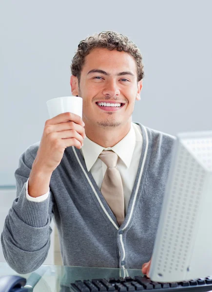 Young businessman drinking a coffe at his desk — Stock Photo, Image