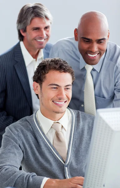 Hombres de negocios sonrientes trabajando en una computadora —  Fotos de Stock