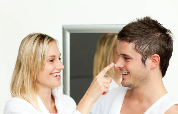Пара веселится со сливками в ванной комнате — стоковое фото