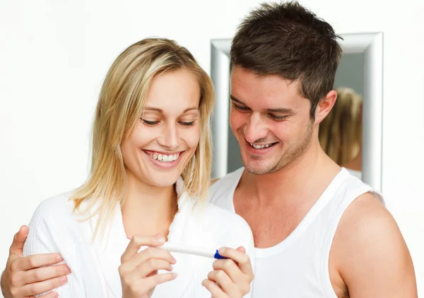 Casal feliz examinando um teste de gravidez — Fotografia de Stock