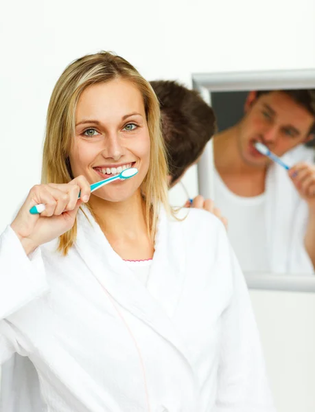 Улыбающаяся женщина чистит зубы своим парнем — стоковое фото