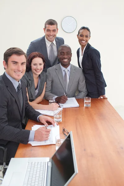 Fem affärer i ett möte som ler mot kameran — Stockfoto