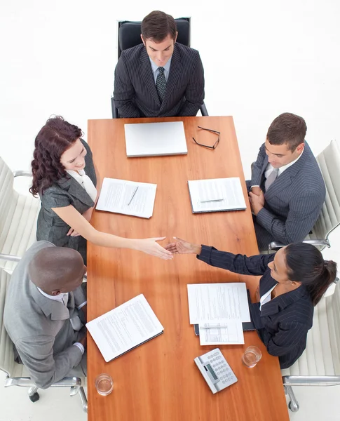 Alto ângulo de empresárias apertando as mãos em uma reunião — Fotografia de Stock
