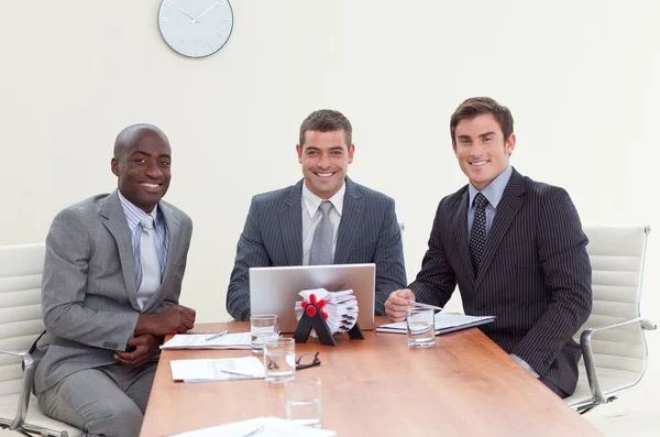 Trois hommes d'affaires dans une réunion souriant — Photo