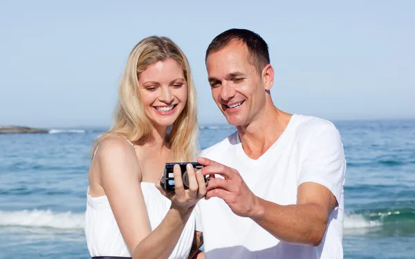 Enamorado casal olhando para fotografia de férias — Fotografia de Stock