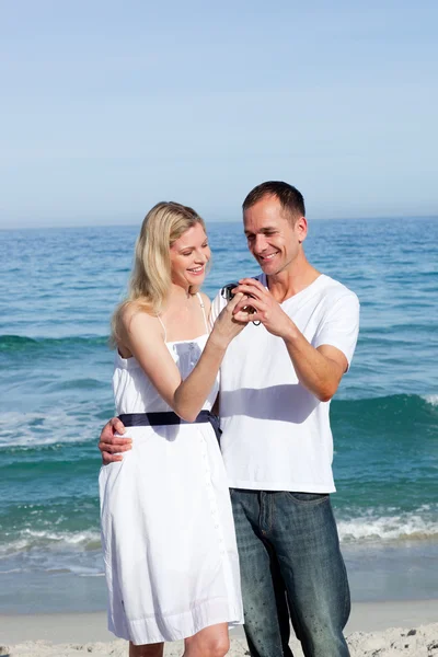 Lyckliga paret tittar på holiday fotografi — Stockfoto