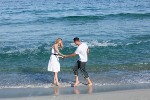 Älskande par ha kul på stranden-linjen — Stockfoto