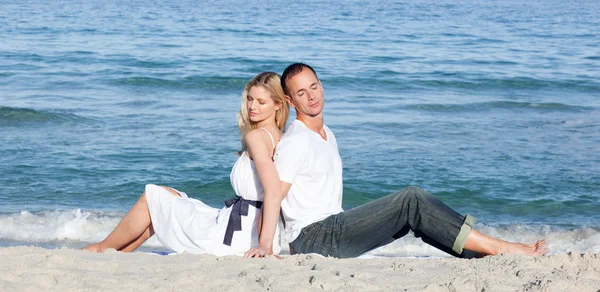 Romantyczna para siedzi na piasku — Zdjęcie stockowe