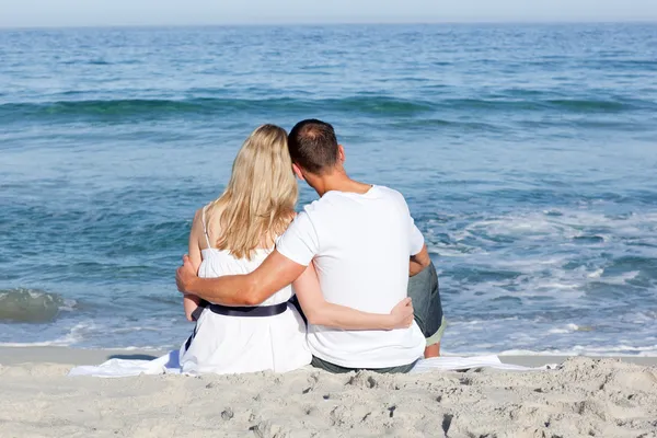 Czuły para siedzi na piasku na plaży — Zdjęcie stockowe