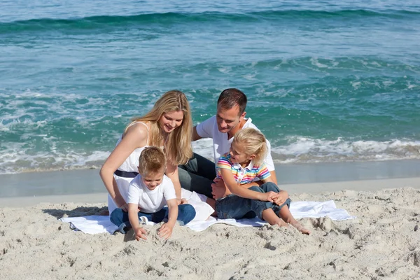 Famiglia felice che gioca sulla sabbia — Foto Stock