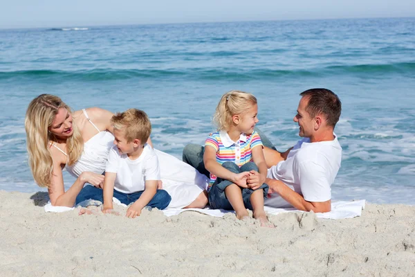 砂の上に座っている幸せな家族 — ストック写真