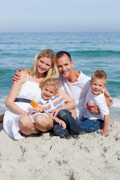 Retrato de una familia alegre sosteniendo protector solar —  Fotos de Stock