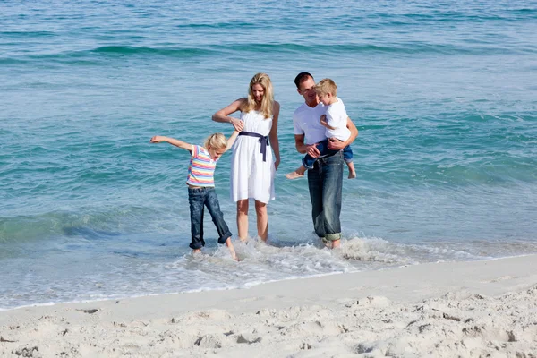 Família animada se divertindo na praia — Fotografia de Stock